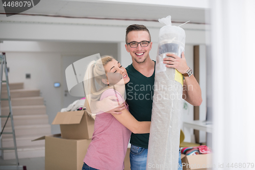 Image of couple carrying a carpet moving in to new home