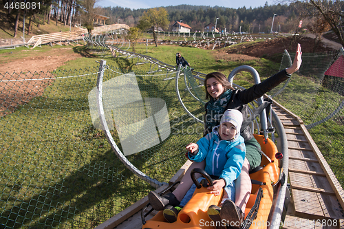 Image of mother and son enjoys driving on alpine coaster