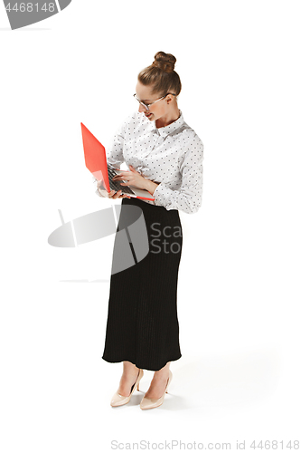 Image of Full length portrait of a smiling female teacher holding a laptop isolated against white background