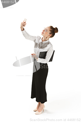 Image of Full length portrait of a smiling female teacher holding a folder isolated against white background