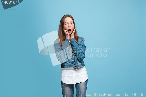 Image of Beautiful teen girl looking suprised isolated on blue