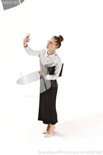 Image of Full length portrait of a smiling female teacher holding a folder isolated against white background