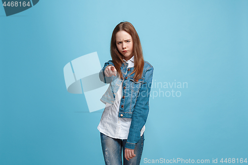 Image of The happy teen girl pointing to you, half length closeup portrait on blue background.
