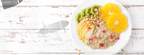 Image of Sweet oatmeal porridge with pine nuts and fresh fruits - pear, o