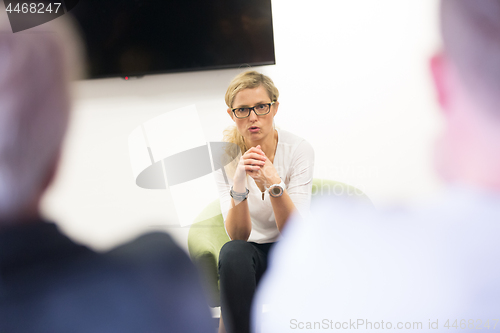 Image of Female candidate presenting her CV in front of business job recuters during job interview in office.