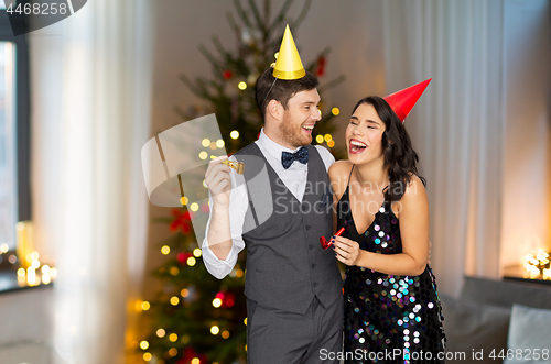 Image of couple with party blowers having fun on christmas