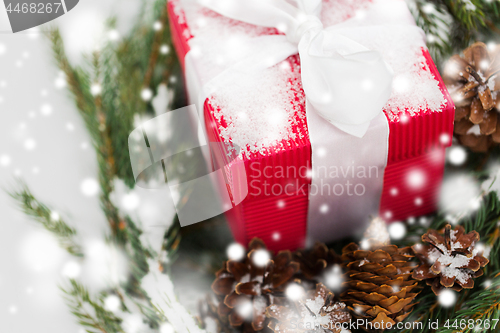 Image of close up of christmas gift and fir wreath on snow