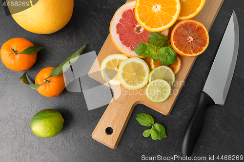 Image of close up of fruits and knife on slate table top