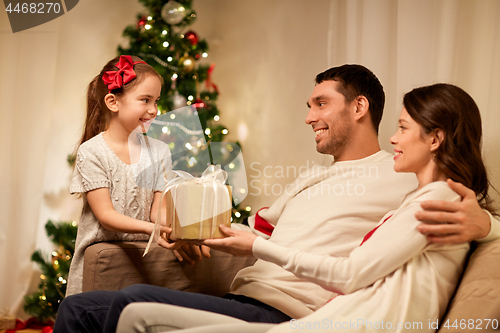 Image of happy family with christmas present at home