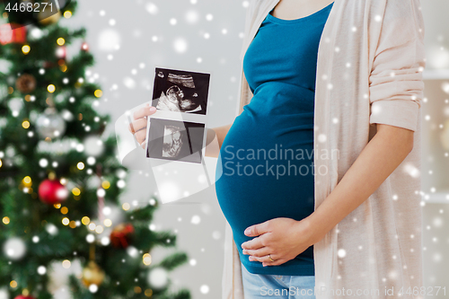 Image of pregnant woman with ultrasound images at christmas