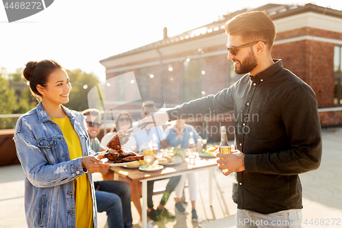 Image of happy friends at barbecue party on rooftop
