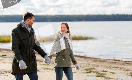 Image of couple walking along autumn beach