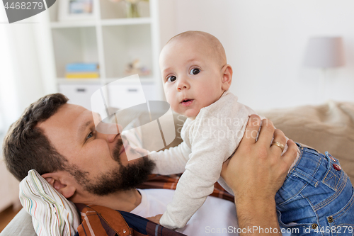 Image of happy father with little baby boy at home