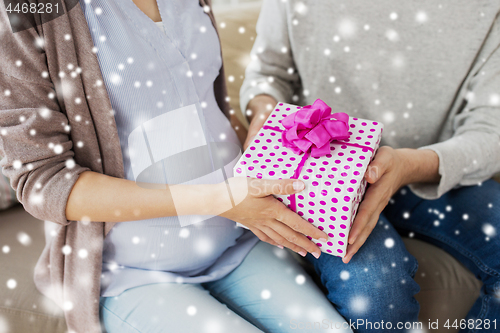 Image of close up of man giving present to pregnant wife