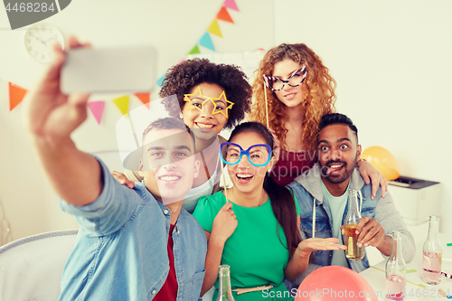 Image of happy team taking selfie at office party