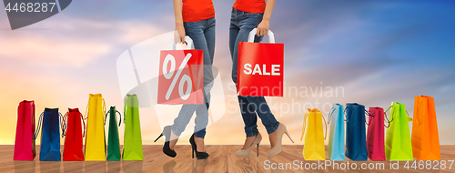 Image of close up of women with sale sign on shopping bags