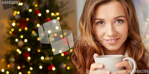 Image of happy woman with cup of tea or coffee on christmas