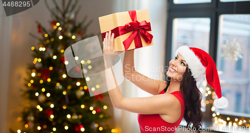 Image of beautiful woman with christmas gift at home