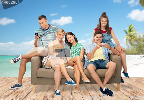 Image of friends with tablet pc and smartphones over beach