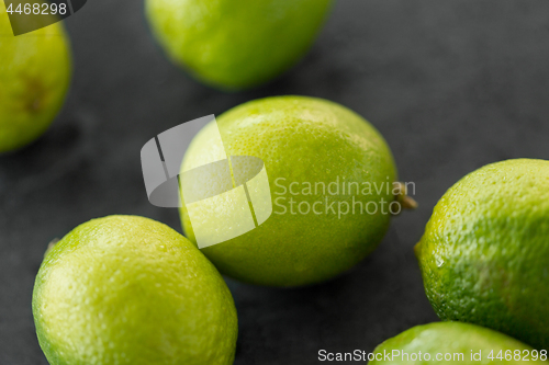 Image of close up of whole limes on slate table top