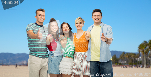 Image of happy friends showing thumbs up over venice beach