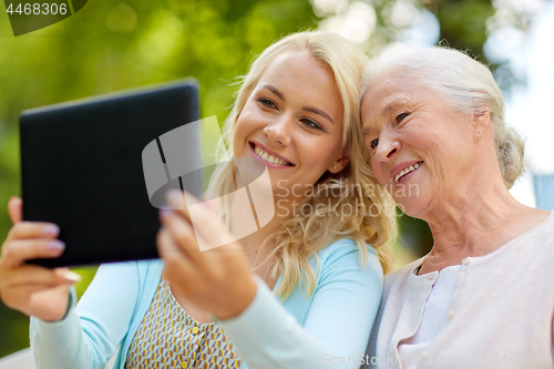 Image of daughter with tablet pc and senior mother at park