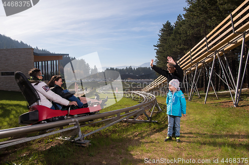 Image of Happy family driving on alpine coaster