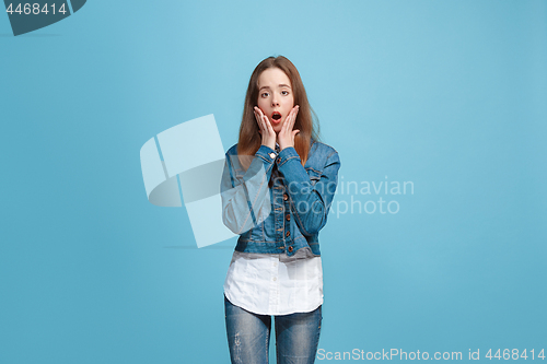 Image of Beautiful teen girl looking suprised isolated on blue