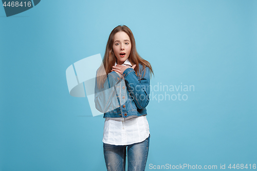 Image of Beautiful teen girl looking suprised isolated on blue