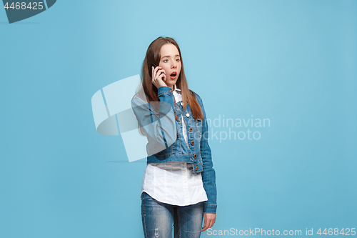 Image of Beautiful teen girl looking suprised isolated on blue
