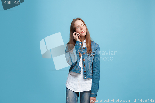 Image of The happy teen girl standing and smiling against pink background.