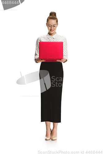 Image of Full length portrait of a smiling female teacher holding a laptop isolated against white background
