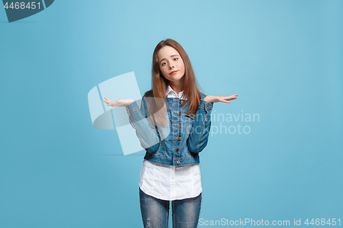 Image of Beautiful teen girl looking suprised and bewildered isolated on blue