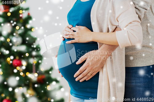 Image of man and pregnant woman home at christmas