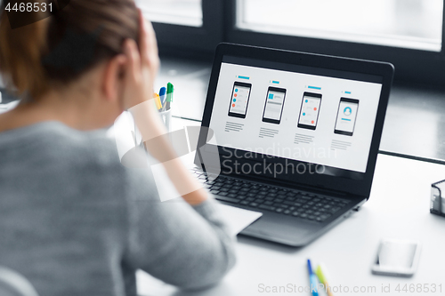 Image of stressed designer with user interface on laptop