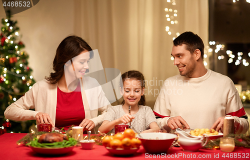 Image of happy family having christmas dinner at home