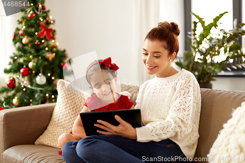 Image of mother and daughter with tablet pc on christmas