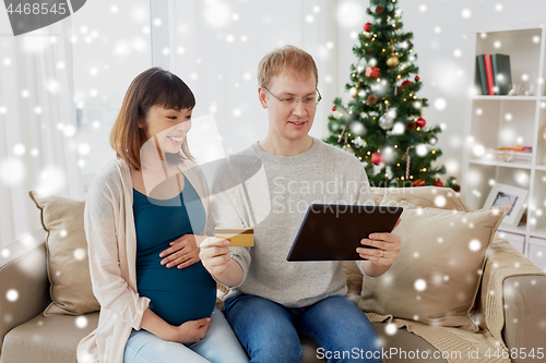 Image of man and pregnant wife shopping online at christmas