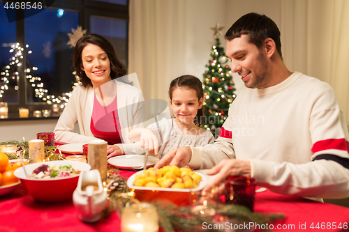 Image of happy family having christmas dinner at home