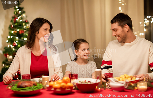 Image of happy family having christmas dinner at home