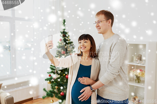 Image of happy family couple taking selfie at christmas