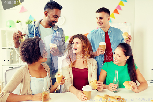 Image of happy friends or team eating at office party