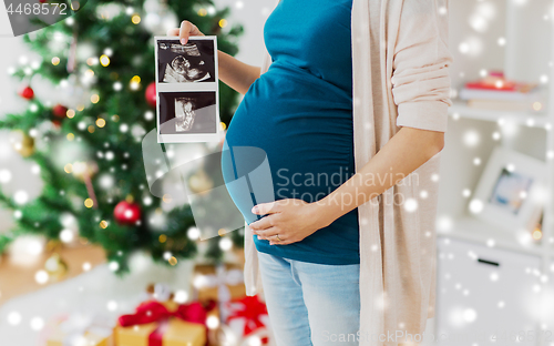 Image of pregnant woman with ultrasound images at christmas