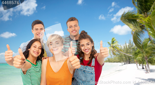 Image of friends showing thumbs up over tropical beach