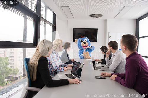 Image of boss dresed as bear having fun with business people in trendy of