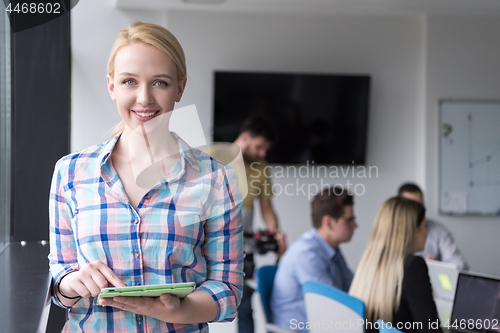 Image of Pretty Businesswoman Using Tablet In Office Building by window