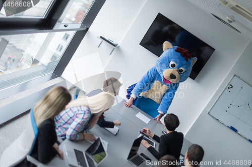 Image of boss dresed as bear having fun with business people in trendy of