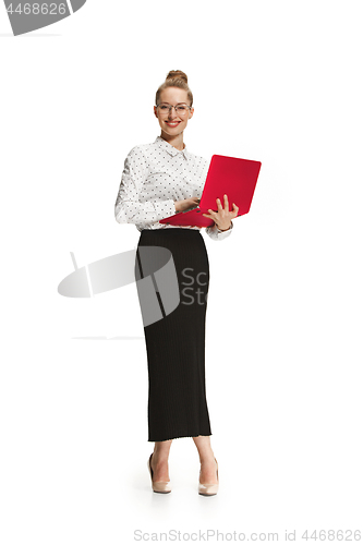 Image of Full length portrait of a smiling female teacher holding a laptop isolated against white background