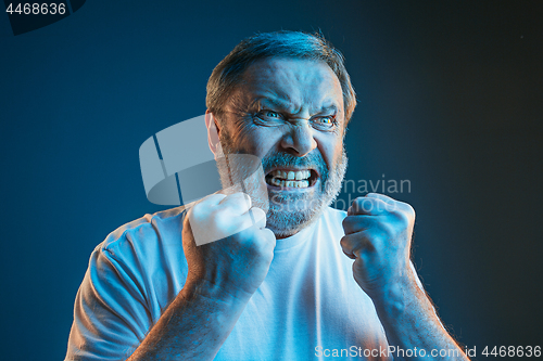 Image of The senior emotional angry man screaming on blue studio background