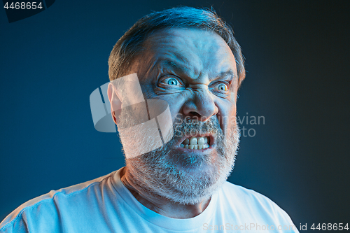 Image of The senior emotional angry man screaming on blue studio background